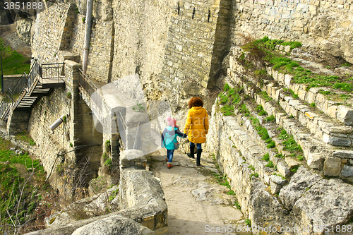 Image of Girl with mother walking along medieval wall