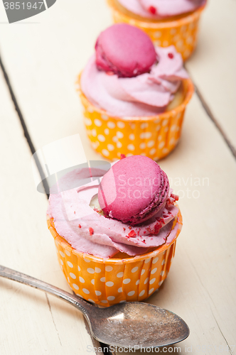 Image of pink berry cream cupcake with macaroon on top