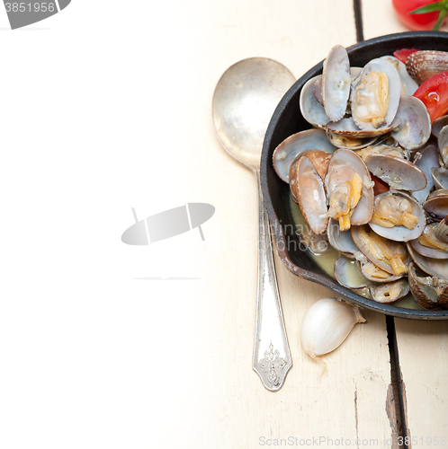 Image of fresh clams on an iron skillet