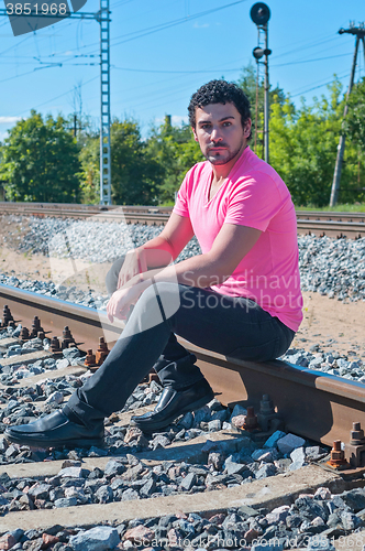 Image of One man in pink on train tracks