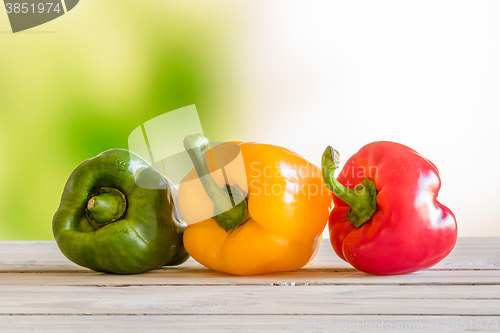 Image of Pepper on a row on a wooden table