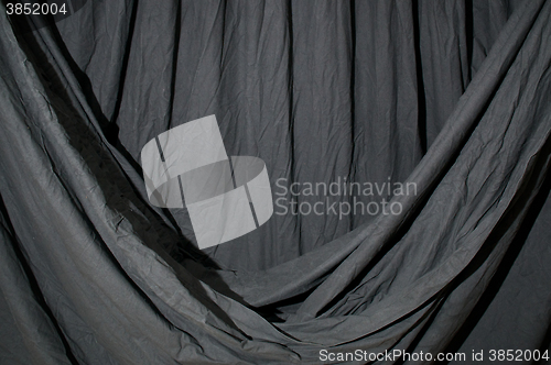 Image of Draped black backdrop cloth lit by blue green gel