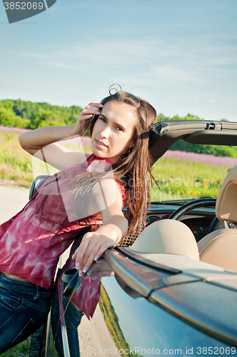 Image of Lovely brunette female near car