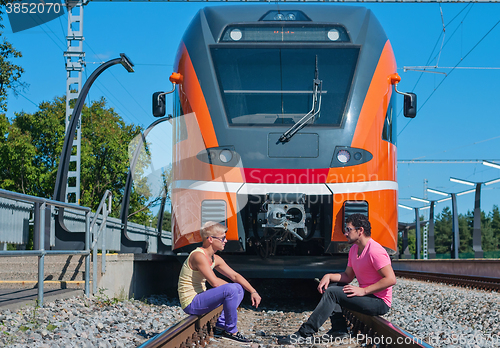 Image of Young trendy guys in front of train