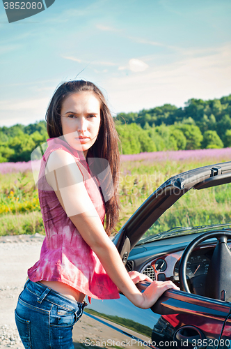 Image of Gorgeous brunette female standing near car