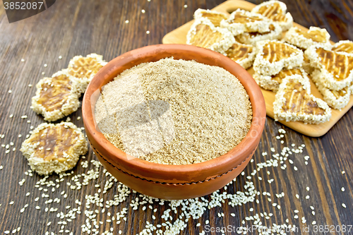 Image of Flour sesame in clay bowl with cookies on board