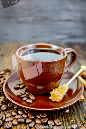 Image of Coffee in brown cup with sugar and grain on board