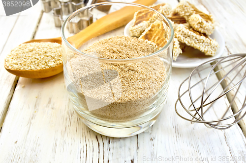 Image of Flour sesame in glassful with spoon on board