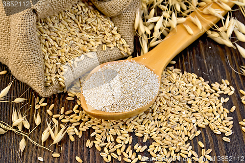 Image of Bran flakes oat in spoon with grains on board