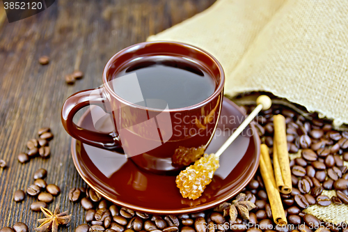 Image of Coffee in brown cup with sugar and bag on board