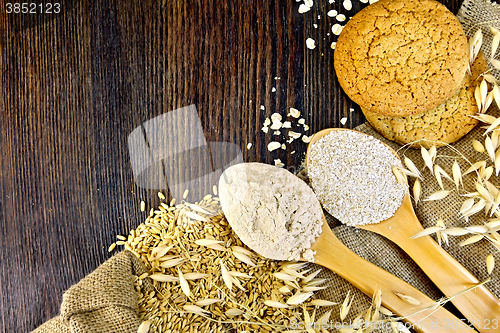 Image of Flour and bran oat in spoon with grains on board