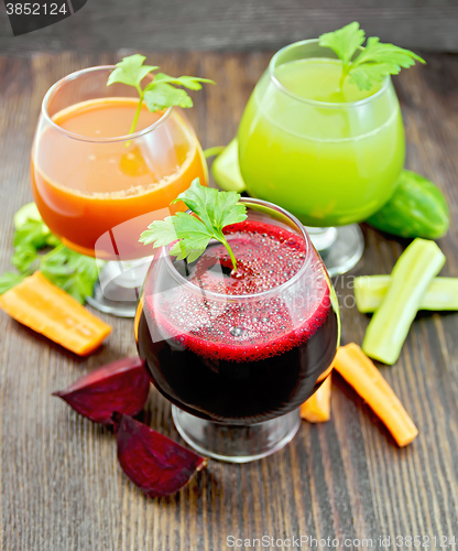 Image of Juice beet and cucumber in wineglass on dark board