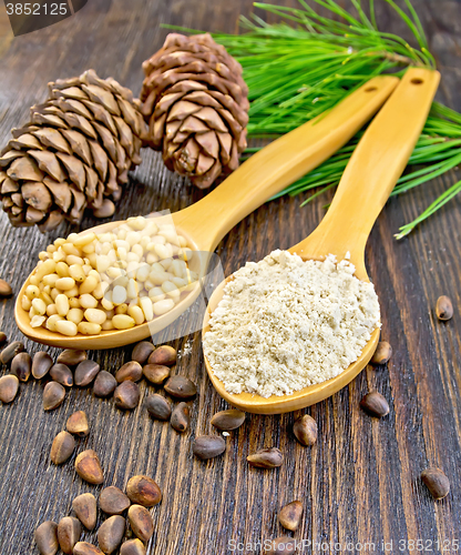 Image of Flour and nuts cedar in spoon on board