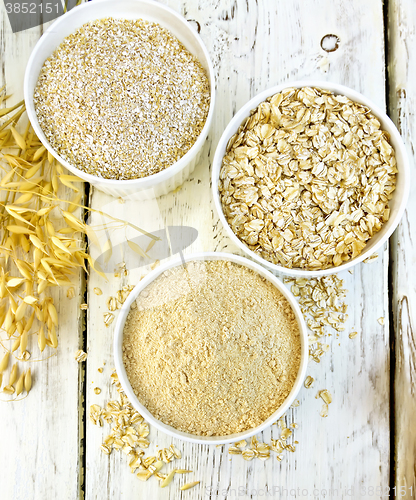 Image of Flour oat in white bowl with bran and flakes on board top