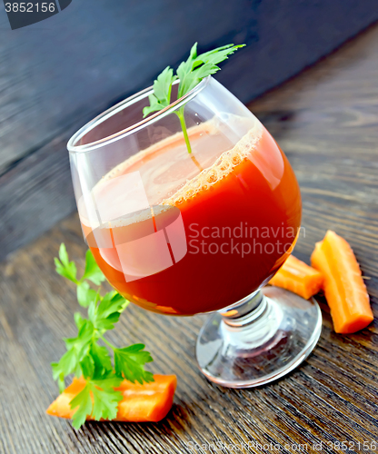 Image of Juice carrot in wineglass on dark board