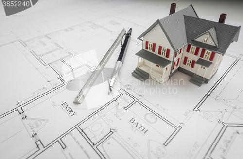 Image of Model Home, Engineer Pencil and Ruler Resting On House Plans