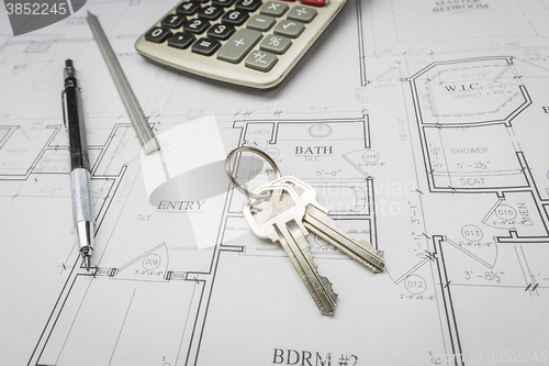 Image of Pencil, Ruler, Calculator and Keys Resting on House Plans