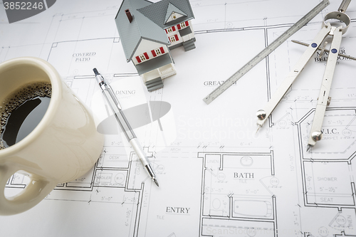 Image of Home, Coffee, Pencil, Ruler and Compass Resting on House Plans