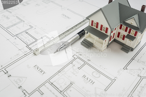 Image of Model Home, Engineer Pencil and Ruler Resting On House Plans