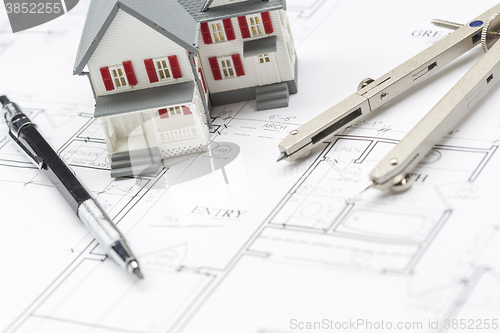 Image of Model Home, Pencil and Compass Resting On House Plans