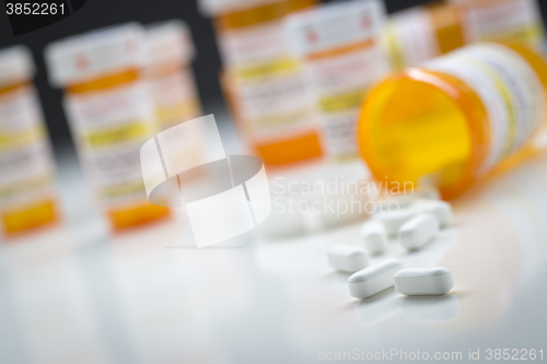 Image of Medicine Bottles Behind Pills Spilling From Fallen Bottle