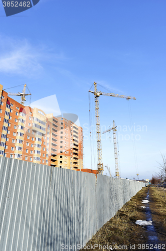 Image of Crane and building construction site against blue sky