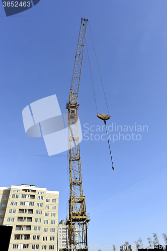 Image of Crane and building construction site against blue sky