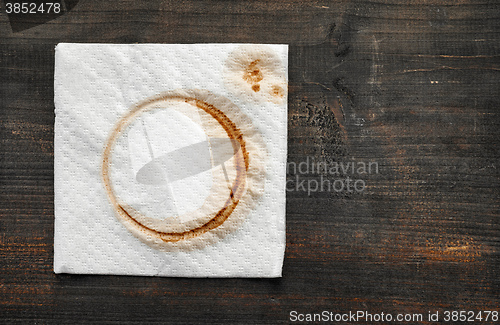Image of used paper napkin on dark wooden table