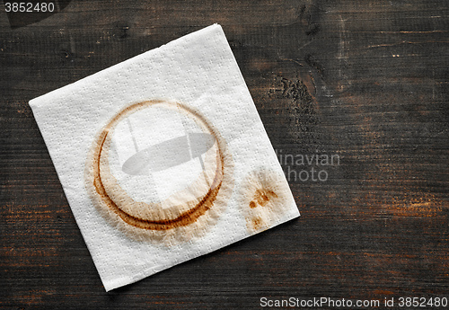 Image of used paper napkin on dark wooden table