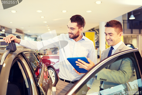 Image of happy man with car dealer in auto show or salon