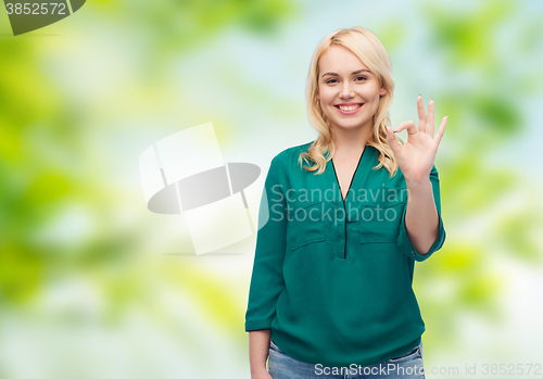 Image of smiling young woman in shirt showing ok hand sign