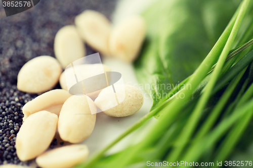 Image of close up of peeled peanuts, greens and seeds