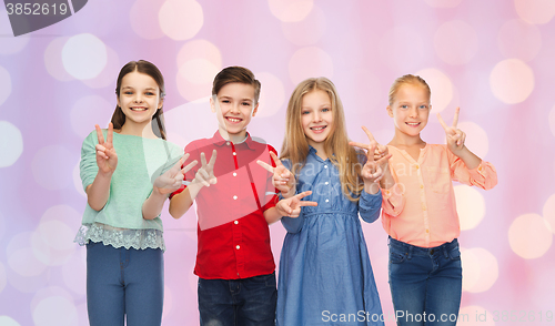 Image of happy boy and girls showing peace hand sign