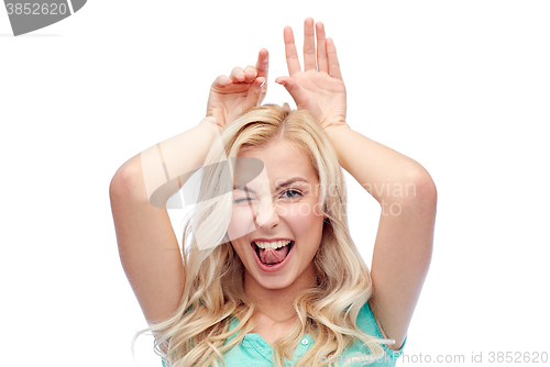 Image of happy smiling young woman making bunny ears