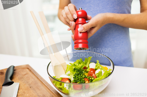 Image of close up of woman cooking vegetable salad at home