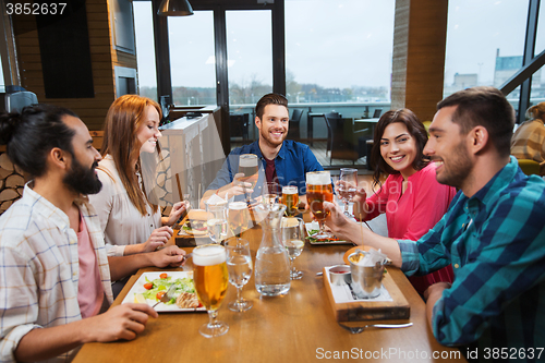 Image of friends dining and drinking beer at restaurant