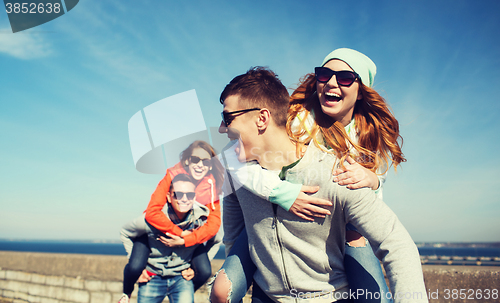 Image of happy teenage friends having fun outdoors