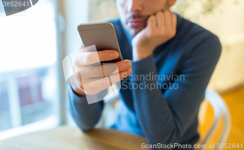 Image of close up of man with smartphones at cafe