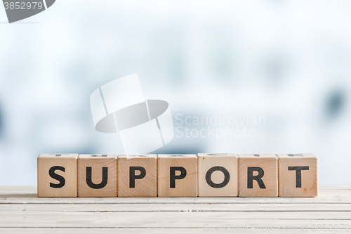 Image of Support sign on a wooden desk