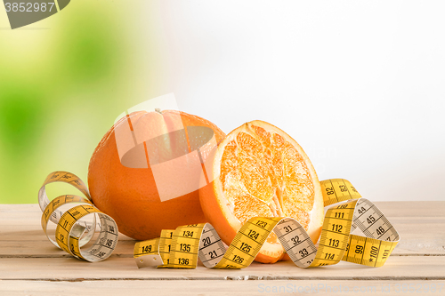 Image of Orange fruit with a yellow measure tape