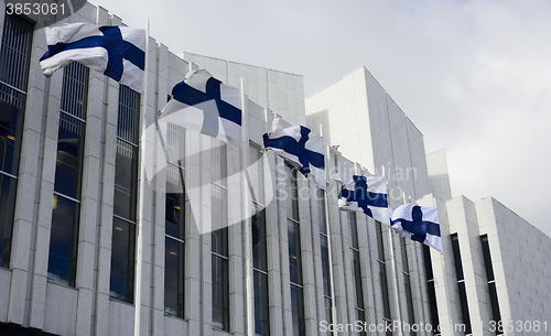 Image of waving Finnish flags against of The Finlandia Hall