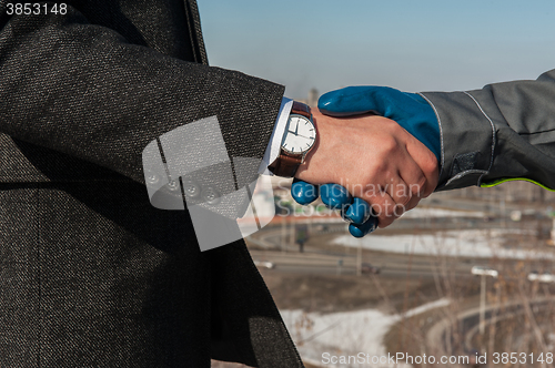 Image of worker shakes hands with businessman