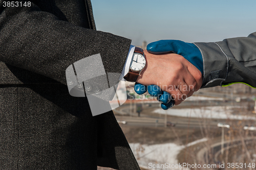 Image of worker shakes hands with businessman