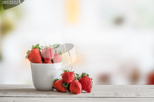 Image of Red strawberries in a white cup
