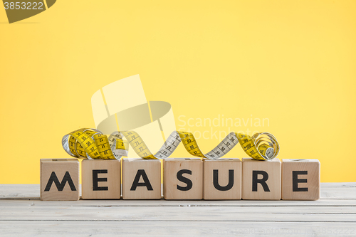 Image of Measure tape on a wooden sign