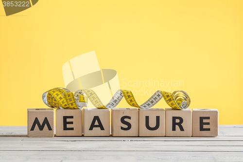 Image of Measure tape on a wooden sign