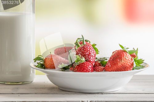 Image of Strawberries on a plate with a bottle of milk
