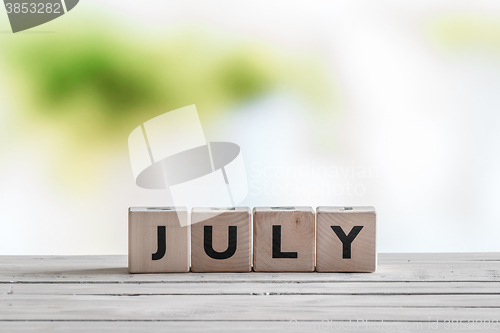 Image of July sign on a wooden table