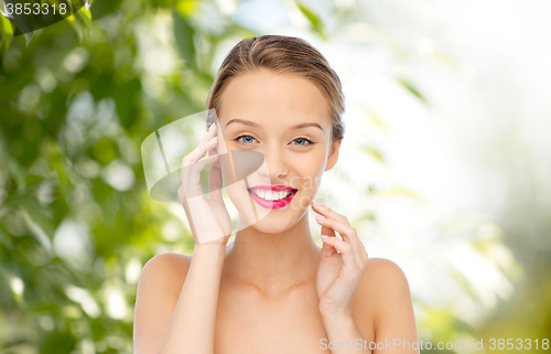 Image of smiling young woman with pink lipstick on lips