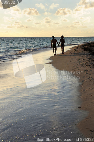 Image of Couple walking on a beach